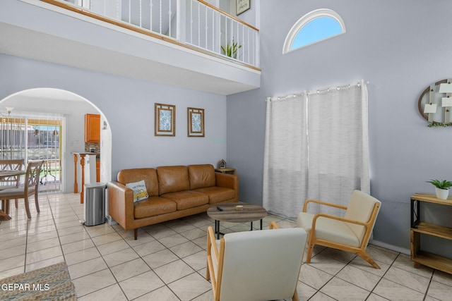 1640 Dennis Babjack Dr, El Paso, TX 79936 - living area featuring arched walkways, a towering ceiling, healthy amount of natural light, and light tile patterned flooring