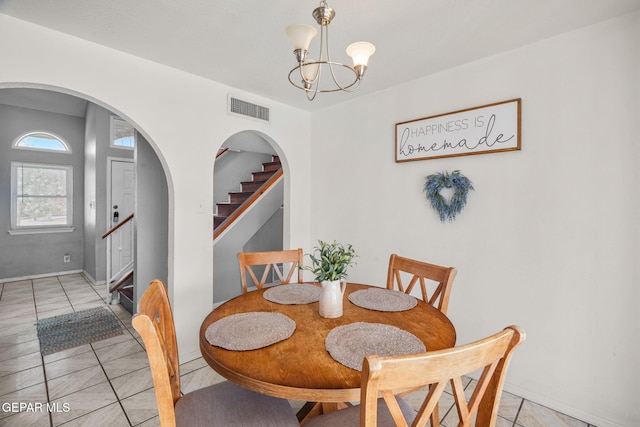 1640 Dennis Babjack Dr, El Paso, TX 79936 - dining area with arched walkways, stairway, a chandelier, baseboards, and light tile patterned floors
