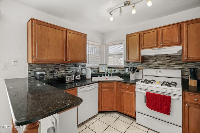 1640 Dennis Babjack Dr, El Paso, TX 79936 - kitchen with under cabinet range hood, white appliances, a sink, and backsplash