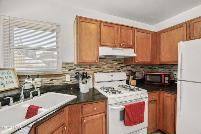 1640 Dennis Babjack Dr, El Paso, TX 79936 - kitchen featuring white appliances, under cabinet range hood, a sink, and backsplash