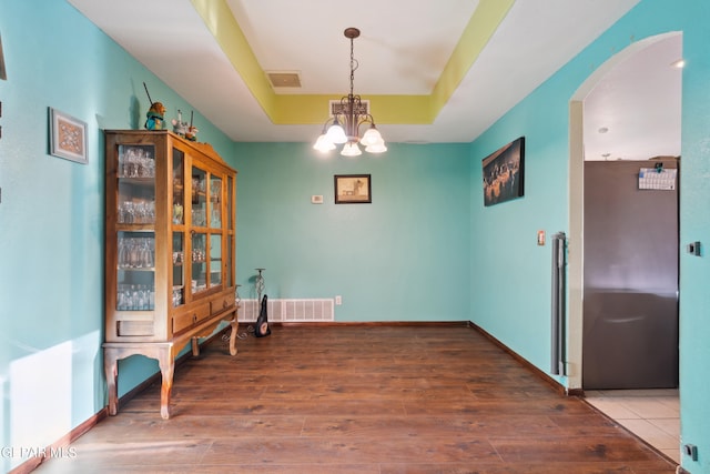 10819 Loma De Amor Ln, El Paso, TX 79934 - dining area featuring arched walkways, wood finished floors, a raised ceiling, and a chandelier