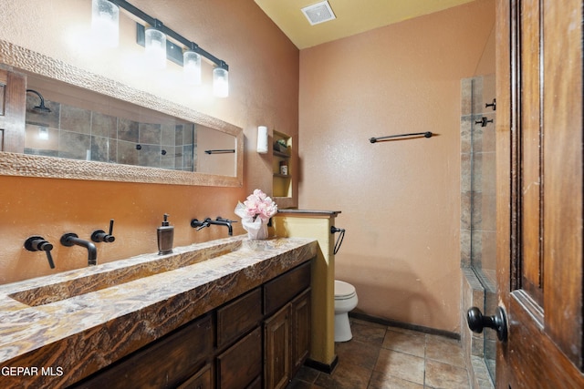 10819 Loma De Amor Ln, El Paso, TX 79934 - full bathroom featuring toilet, vanity, a textured wall, and a tile shower