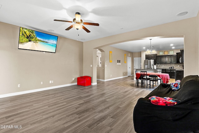 5505 Valley Cedar Dr, El Paso, TX 79932 - living room featuring arched walkways, ceiling fan, wood finished floors, baseboards, and a chandelier