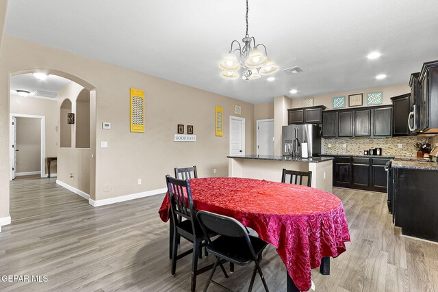 5505 Valley Cedar Dr, El Paso, TX 79932 - dining space featuring arched walkways, light wood-style floors, a chandelier, baseboards, and recessed lighting