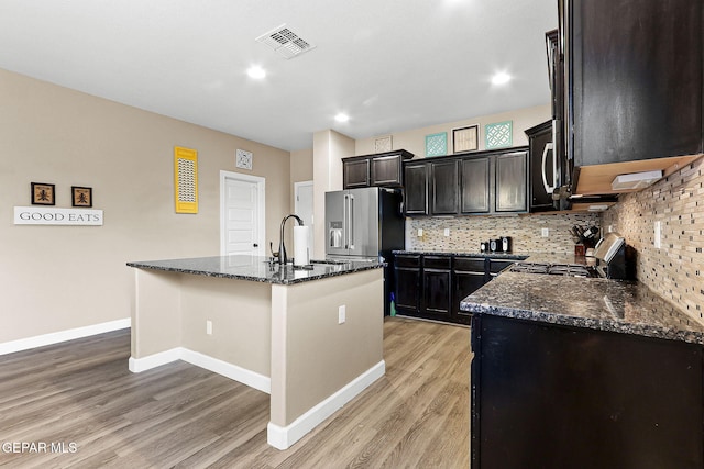 5505 Valley Cedar Dr, El Paso, TX 79932 - kitchen featuring appliances with stainless steel finishes, dark stone countertops, a sink, light wood finished floors, and recessed lighting