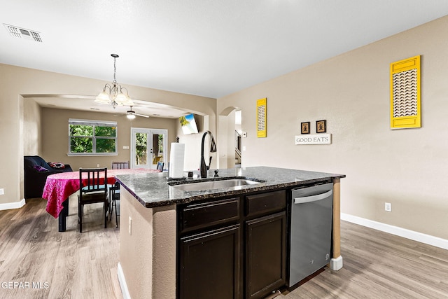 5505 Valley Cedar Dr, El Paso, TX 79932 - kitchen featuring stainless steel dishwasher, a sink, arched walkways, light wood finished floors, and dark stone countertops
