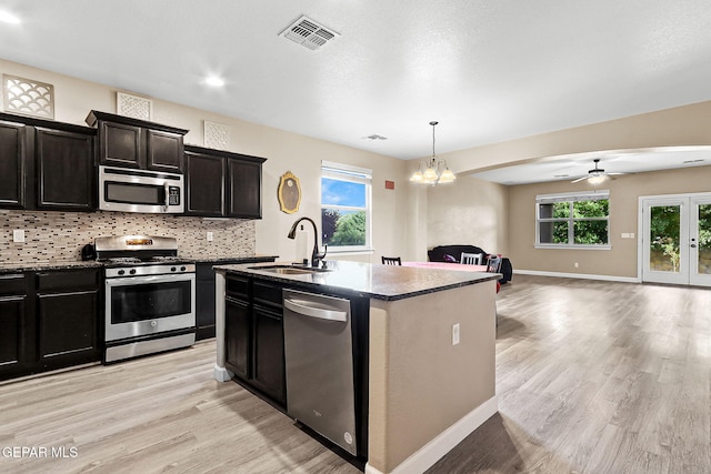 5505 Valley Cedar Dr, El Paso, TX 79932 - kitchen featuring appliances with stainless steel finishes, a sink, light wood-style flooring, open floor plan, and tasteful backsplash