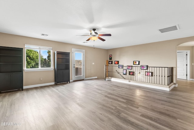 5505 Valley Cedar Dr, El Paso, TX 79932 - unfurnished living room featuring arched walkways, a ceiling fan, baseboards, and wood finished floors