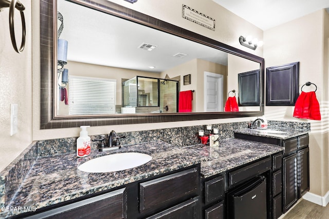 5505 Valley Cedar Dr, El Paso, TX 79932 - full bath with double vanity, a shower stall, and wood finished floors
