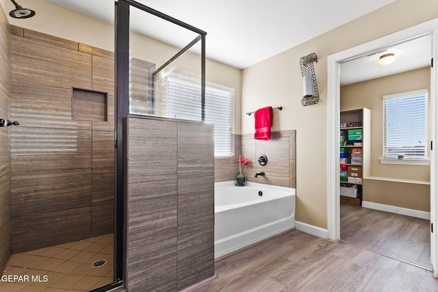 5505 Valley Cedar Dr, El Paso, TX 79932 - bathroom with wood finished floors, a stall shower, a garden tub, and baseboards