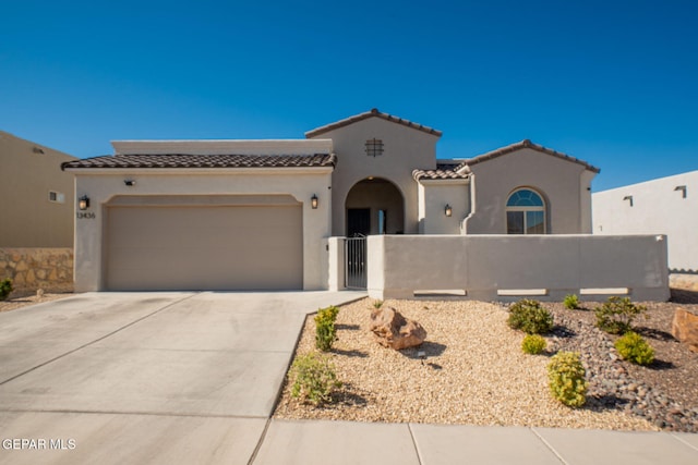 13436 Emerald Crystal Dr, El Paso, TX 79928 - view of front of house with a tiled roof, concrete driveway, a fenced front yard, an attached garage, and stucco siding