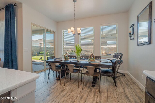 13436 Emerald Crystal Dr, El Paso, TX 79928 - dining area with light wood-type flooring, a chandelier, and baseboards