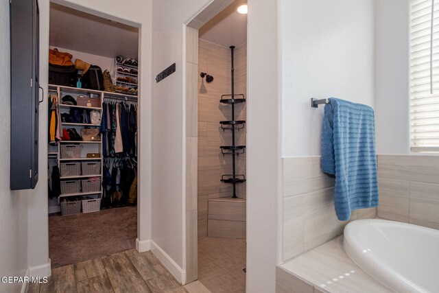 13436 Emerald Crystal Dr, El Paso, TX 79928 - full bath with a tile shower, a bath, a spacious closet, and wood finished floors