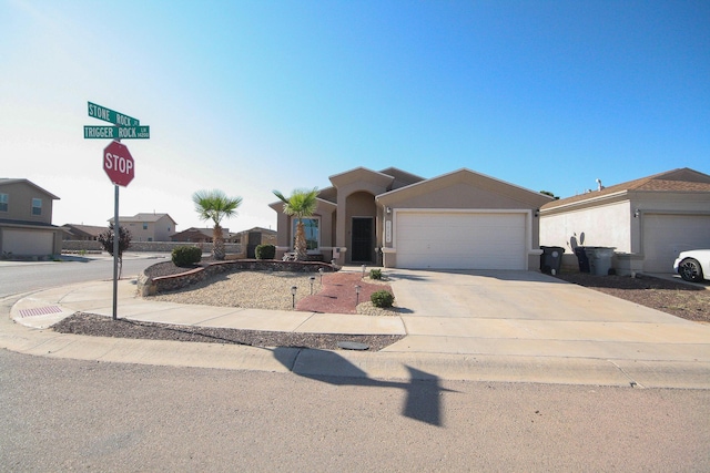 14244 Trigger Rock Ln, El Paso, TX 79938 - view of front of property with an attached garage, concrete driveway, and stucco siding