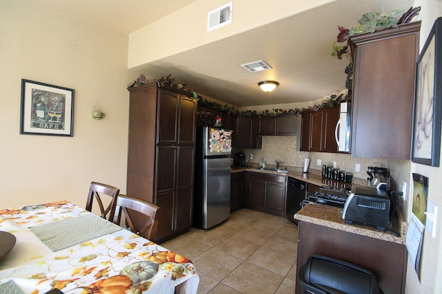 14244 Trigger Rock Ln, El Paso, TX 79938 - kitchen with freestanding refrigerator, a sink, white microwave, light tile patterned floors, and black dishwasher