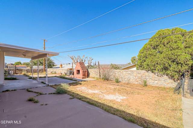 10224 Galahad Way, El Paso, TX 79924 - fenced backyard with an outdoor stone fireplace and a patio