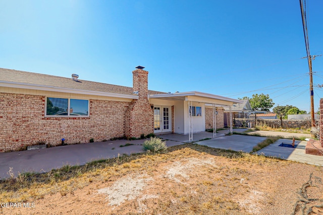 10224 Galahad Way, El Paso, TX 79924 - rear view of property featuring a patio area, a chimney, brick siding, and french doors