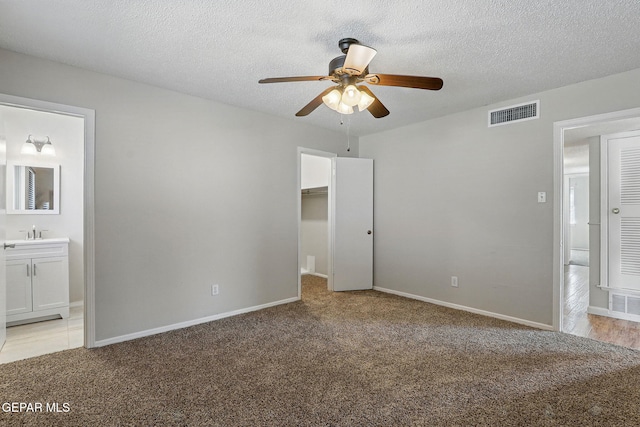 10224 Galahad Way, El Paso, TX 79924 - unfurnished bedroom with light carpet, connected bathroom, baseboards, and a textured ceiling