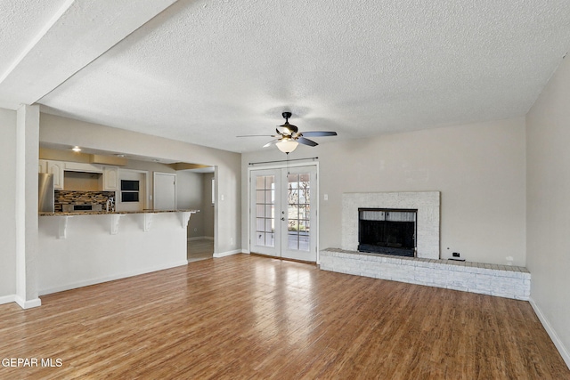 10224 Galahad Way, El Paso, TX 79924 - unfurnished living room with wood finished floors, a textured ceiling, baseboards, and ceiling fan