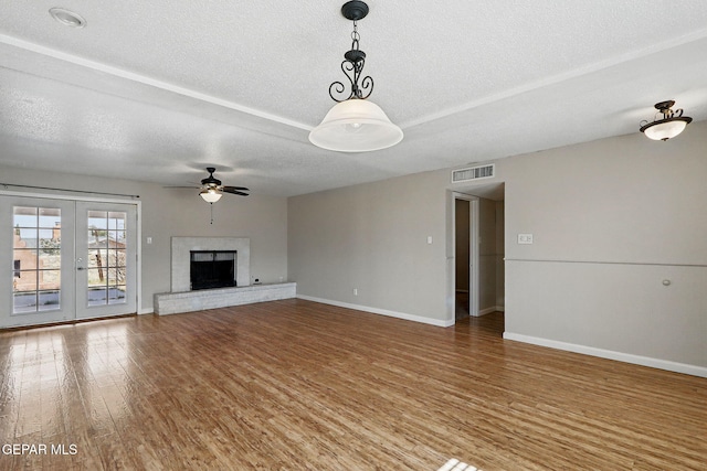 10224 Galahad Way, El Paso, TX 79924 - unfurnished living room with a textured ceiling, baseboards, wood finished floors, ceiling fan, and a fireplace with raised hearth