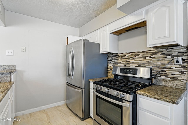 10224 Galahad Way, El Paso, TX 79924 - kitchen with stainless steel appliances, white cabinets, backsplash, baseboards, and dark stone counters