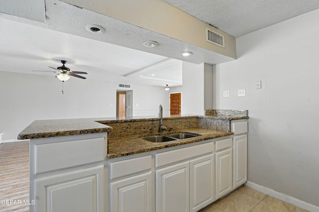 10224 Galahad Way, El Paso, TX 79924 - kitchen with a sink, dark stone countertops, ceiling fan, baseboards, and white cabinets