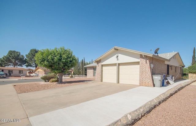 1701 Paul Moran Pl, El Paso, TX 79936 - view of front of property featuring a garage, concrete driveway, and brick siding