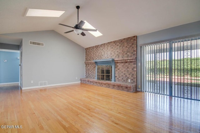 1701 Paul Moran Pl, El Paso, TX 79936 - unfurnished living room featuring a skylight, a ceiling fan, lofted ceiling, wood finished floors, and a fireplace