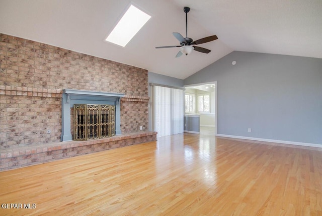 1701 Paul Moran Pl, El Paso, TX 79936 - unfurnished living room featuring a ceiling fan, a fireplace, wood finished floors, a skylight, and baseboards