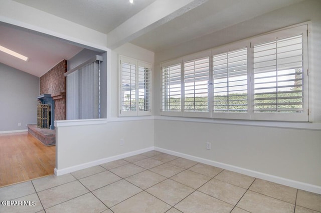 1701 Paul Moran Pl, El Paso, TX 79936 - tiled spare room with baseboards, a fireplace, and vaulted ceiling