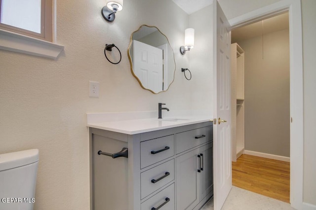 1701 Paul Moran Pl, El Paso, TX 79936 - bathroom with vanity, toilet, wood finished floors, and baseboards