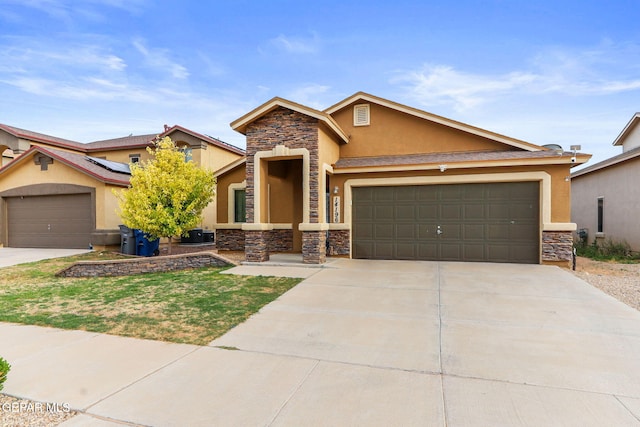 14196 Greg Allen, El Paso, TX 79938 - view of front of property featuring stone siding, stucco siding, concrete driveway, a garage, and roof mounted solar panels