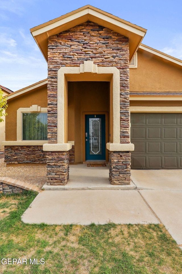 14196 Greg Allen, El Paso, TX 79938 - property entrance featuring stone siding, stucco siding, concrete driveway, and an attached garage
