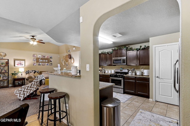 14196 Greg Allen, El Paso, TX 79938 - kitchen featuring appliances with stainless steel finishes, arched walkways, a kitchen bar, open floor plan, and a ceiling fan