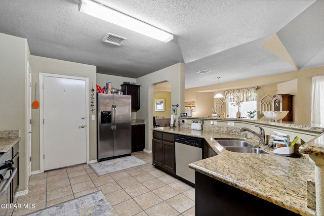 14196 Greg Allen, El Paso, TX 79938 - kitchen with appliances with stainless steel finishes, a sink, arched walkways, light tile patterned floors, and a textured ceiling