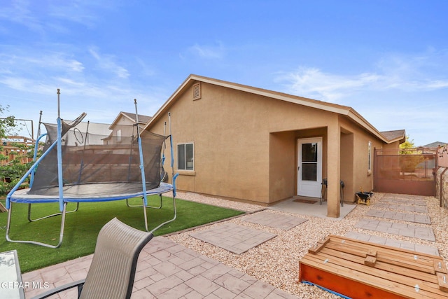 14196 Greg Allen, El Paso, TX 79938 - rear view of property featuring a trampoline, a patio, and stucco siding