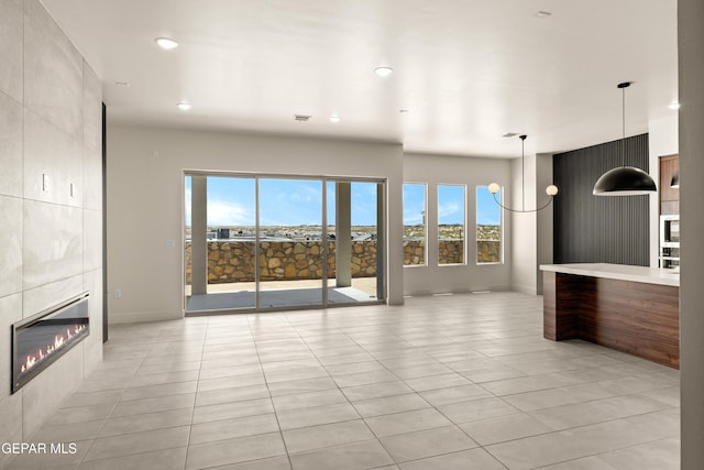 832 Acton St, Horizon City, TX 79928 - unfurnished living room featuring light tile patterned flooring, baseboards, a tile fireplace, and recessed lighting