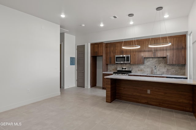 832 Acton St, Horizon City, TX 79928 - kitchen featuring appliances with stainless steel finishes, light countertops, tasteful backsplash, a sink, and pendant lighting