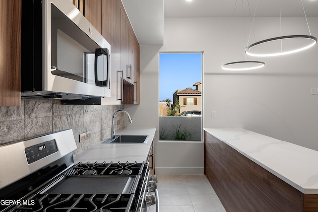 832 Acton St, Horizon City, TX 79928 - kitchen with stainless steel appliances, a sink, modern cabinets, decorative backsplash, and light countertops