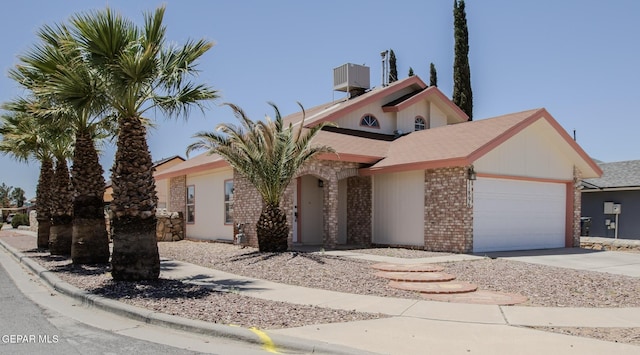 11896 Crimson Sky Dr, El Paso, TX 79936 - view of front of property featuring an attached garage, driveway, brick siding, and central AC