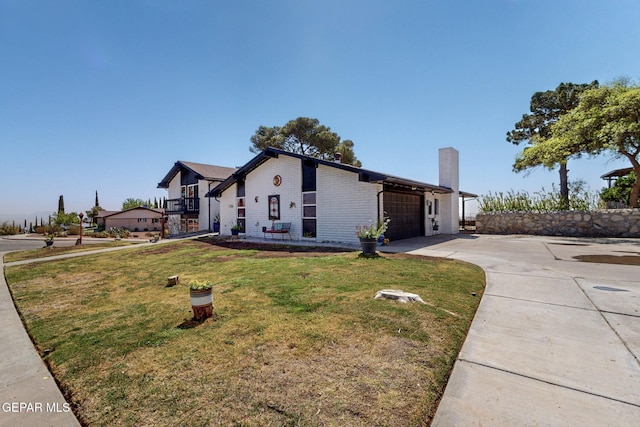 3104 Pagosa Ct, El Paso, TX 79904 - view of side of home with driveway, a garage, a lawn, brick siding, and a chimney