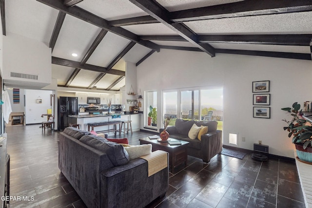 3104 Pagosa Ct, El Paso, TX 79904 - living room featuring beamed ceiling, baseboards, high vaulted ceiling, and a textured ceiling