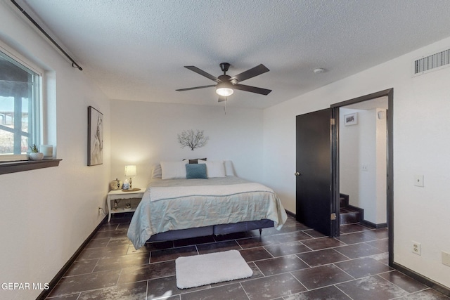 3104 Pagosa Ct, El Paso, TX 79904 - bedroom with a textured ceiling, baseboards, a ceiling fan, and dark tile patterned flooring