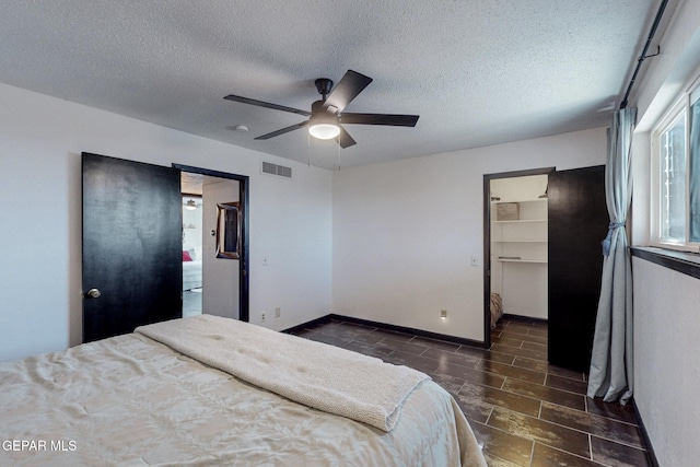 3104 Pagosa Ct, El Paso, TX 79904 - bedroom featuring a textured ceiling, a spacious closet, a ceiling fan, and baseboards