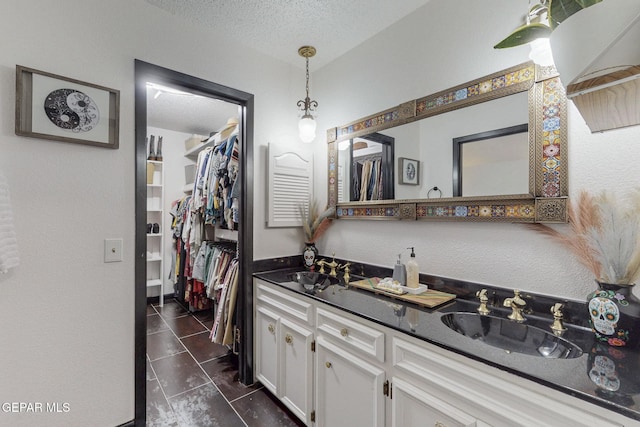 3104 Pagosa Ct, El Paso, TX 79904 - full bath with a textured ceiling, double vanity, and a spacious closet