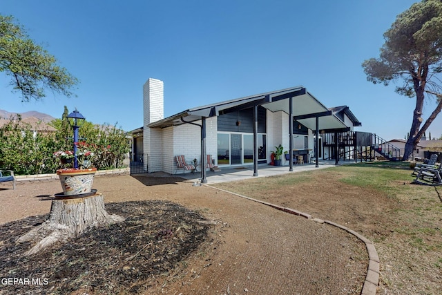 3104 Pagosa Ct, El Paso, TX 79904 - back of house with a chimney, a patio area, brick siding, and a yard