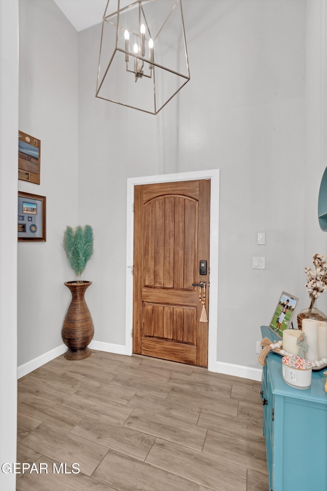 14521 Petralia Ave, El Paso, TX 79938 - foyer entrance featuring a chandelier, a high ceiling, baseboards, and light wood-type flooring