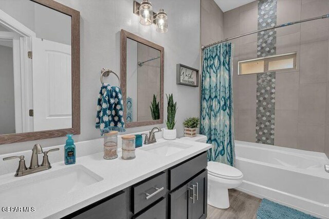 14521 Petralia Ave, El Paso, TX 79938 - bathroom featuring toilet, shower / bathtub combination with curtain, double vanity, and wood finished floors
