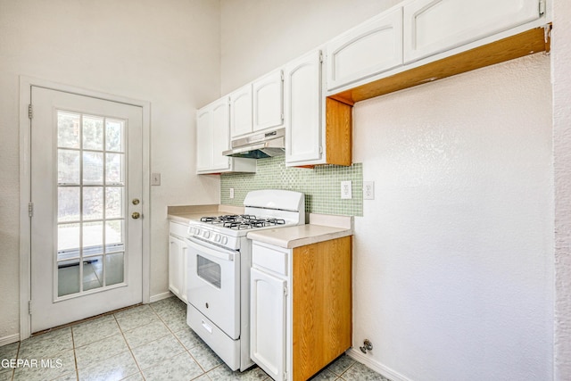 12044 Banner Crest Dr, El Paso, TX 79936 - kitchen with white range with gas stovetop, under cabinet range hood, light countertops, white cabinets, and tasteful backsplash