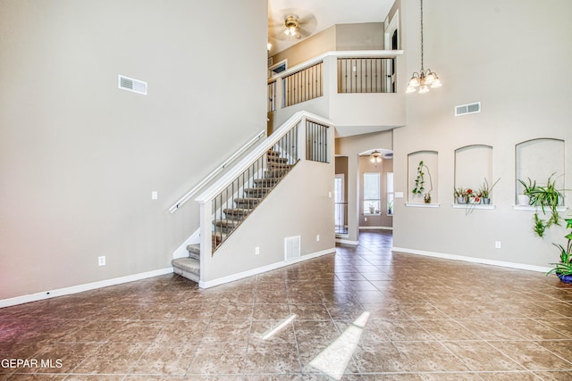 11352 Bullseye St, El Paso, TX 79934 - unfurnished living room featuring a ceiling fan, stairs, a high ceiling, baseboards, and a chandelier